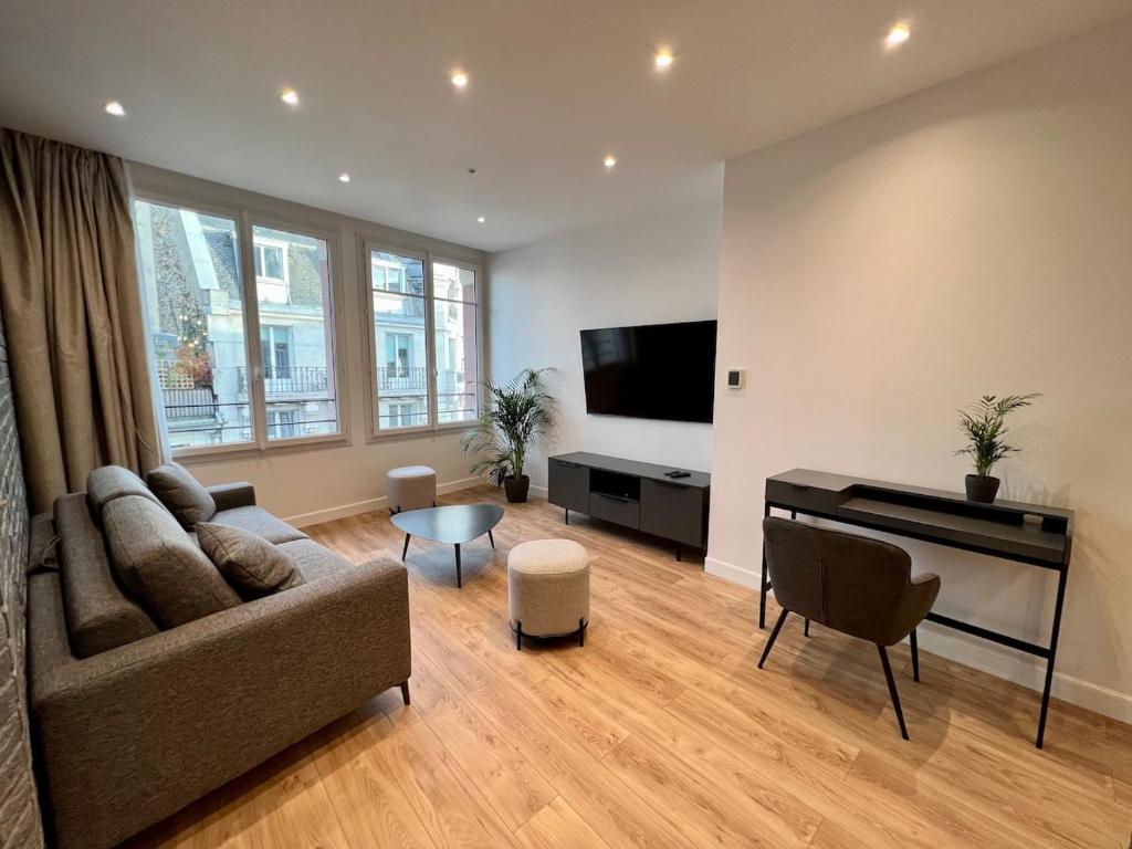 un salon avec un canapé et une télévision à écran plat dans l'établissement Spacious newly renovated loft with AC, à Paris