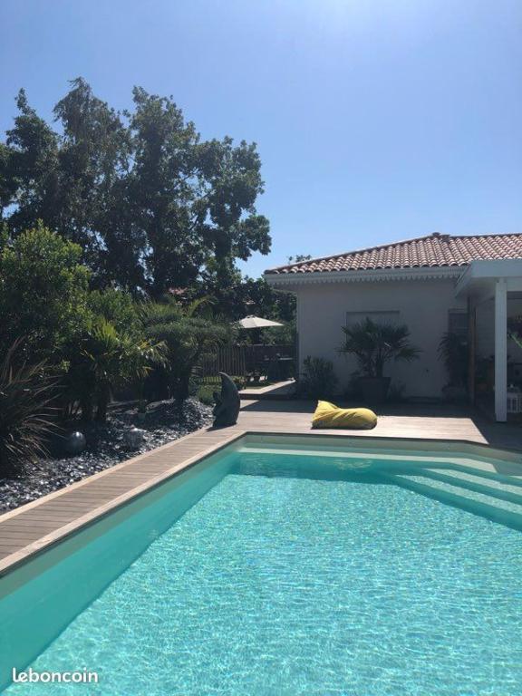 une piscine devant une maison dans l'établissement Maison Andernos Les Bains - Spa Jacuzzi et Piscine, à Andernos-les-Bains