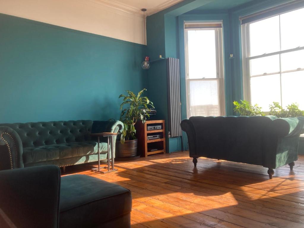 ein Wohnzimmer mit blauen Wänden und einer Couch in der Unterkunft Gavin's Sea Pad in St. Leonards