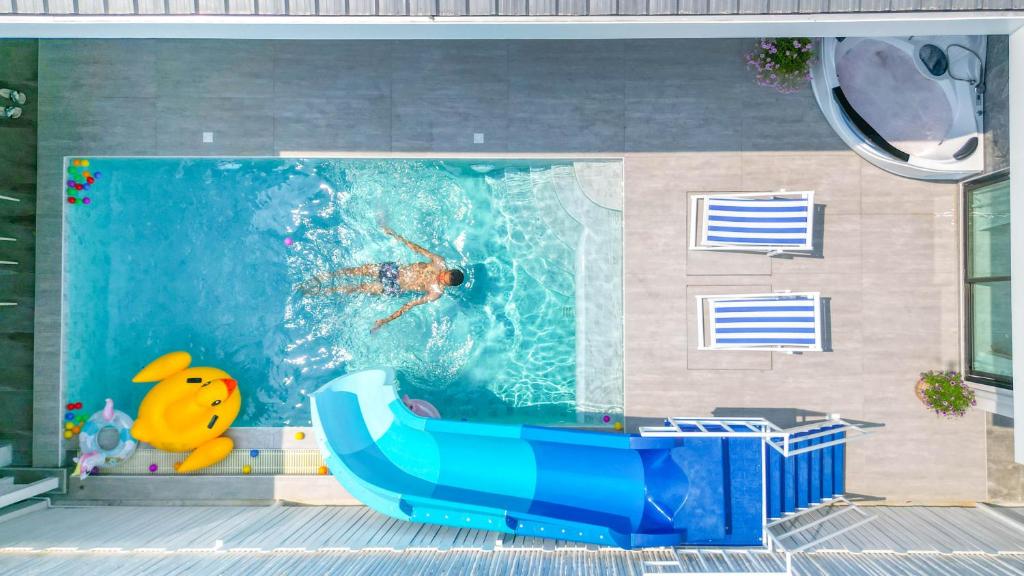 a swimming pool with a blue bath tub in the water at Wana Villa ChaAM in Cha Am