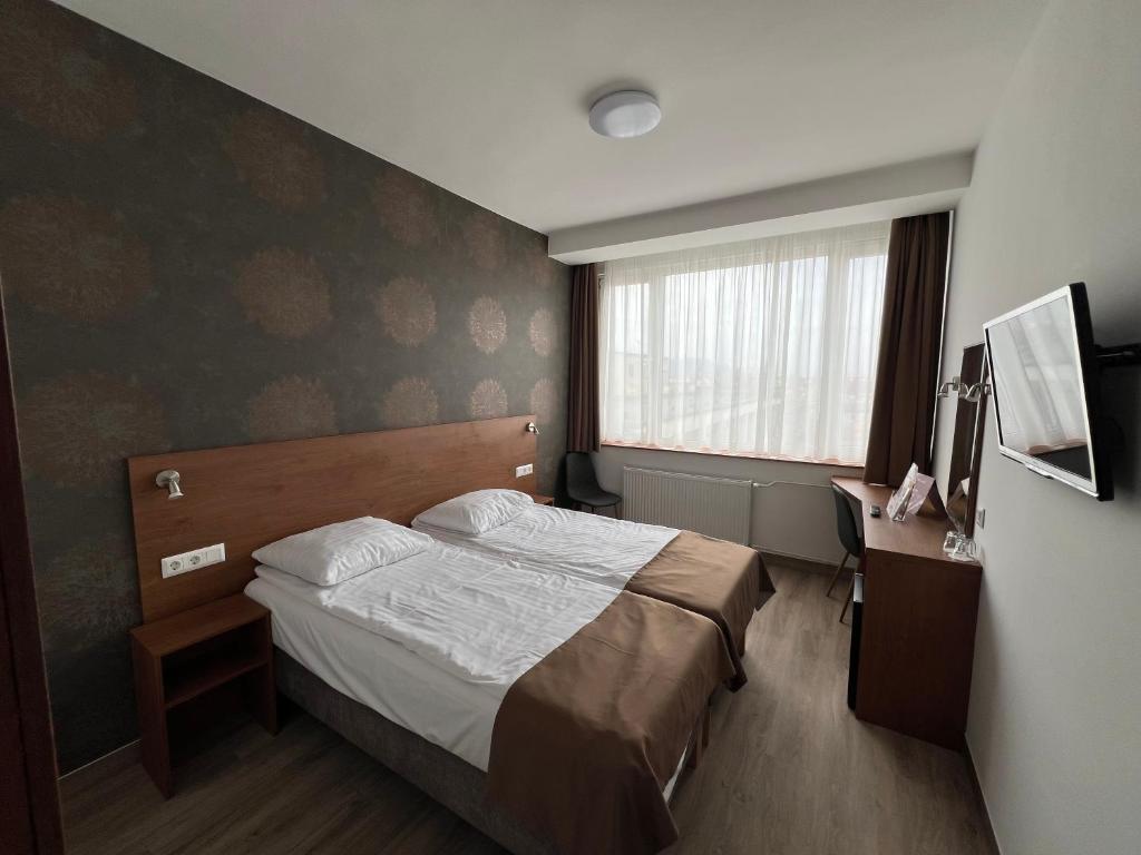 Una habitación de hotel con una cama y una ventana. en Benczur Hotel, en Budapest