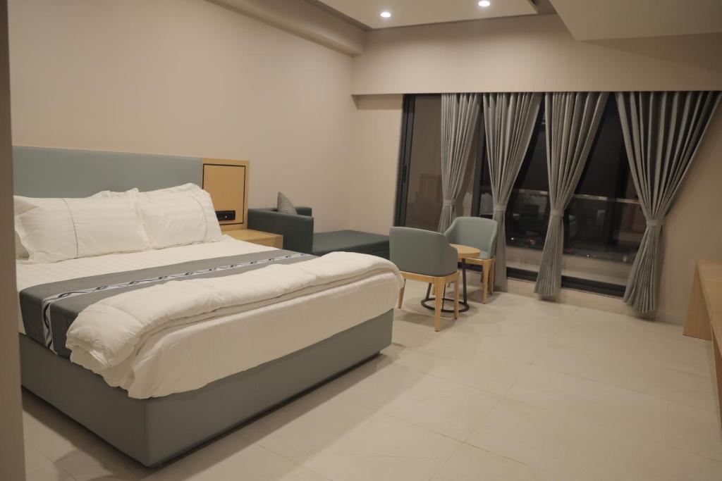 a bedroom with a bed and some chairs and windows at The Aeran Foods & Hospitality in Chhala