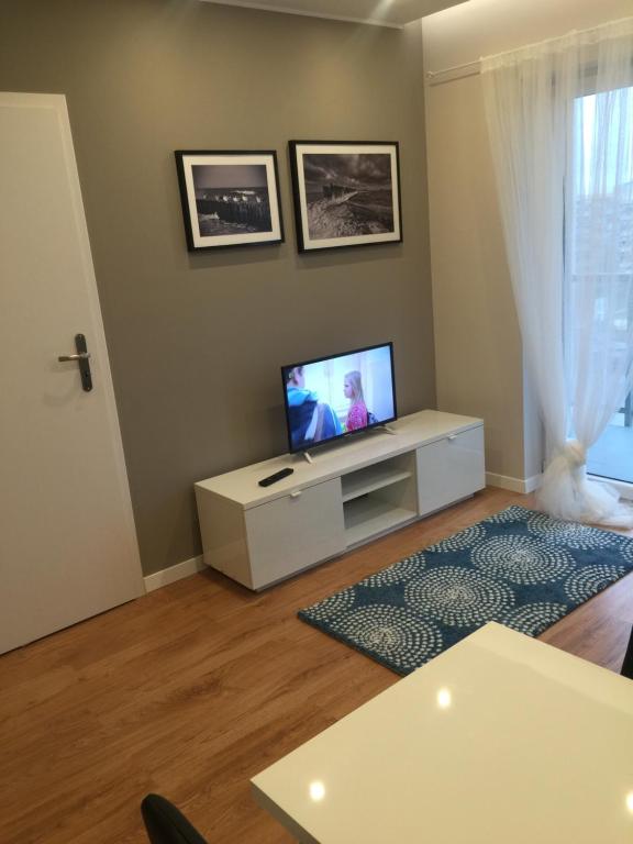 uma sala de estar com uma televisão de ecrã plano na parede em Apartment Gdański Albatros 95 em Gdansk