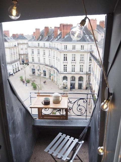 un balcon avec une table et une vue sur une ville dans l'établissement Studio Wabi Sabi Graslin, à Nantes
