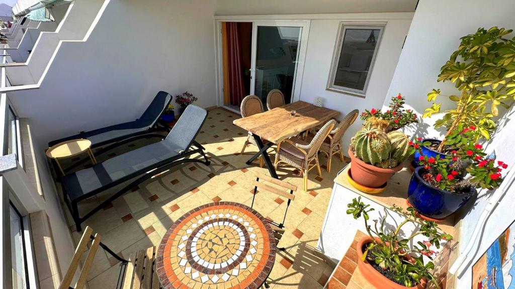 a balcony with a table and chairs and plants at App 308 - Wundervoller Meerblick, sehr zentrale Lage, angenehm ruhig in Tías