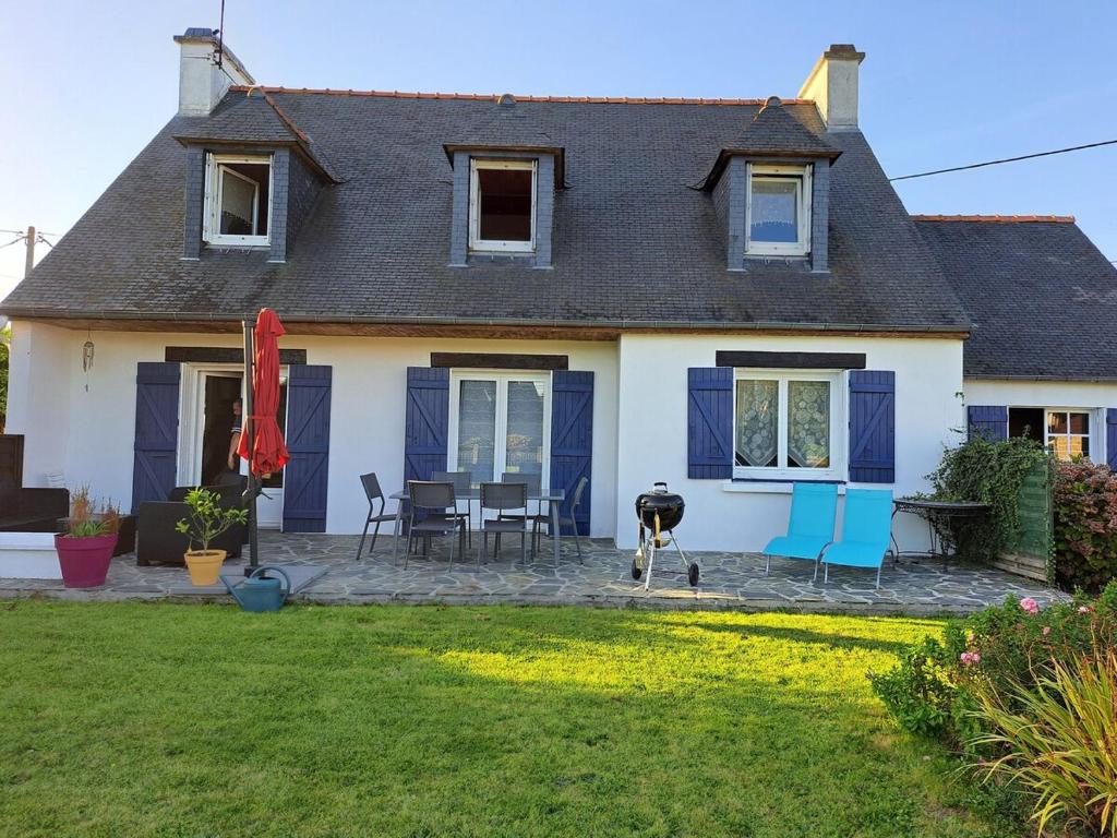 une maison avec des portes bleues, une table et des chaises dans l'établissement Charmante Demeure bretonne, à Plouëc