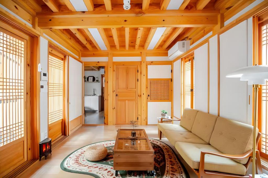 una sala de estar con un sofá y una mesa en Numaru Stay - Luxury Private Hanoks in Seochon, Seoul, en Seúl