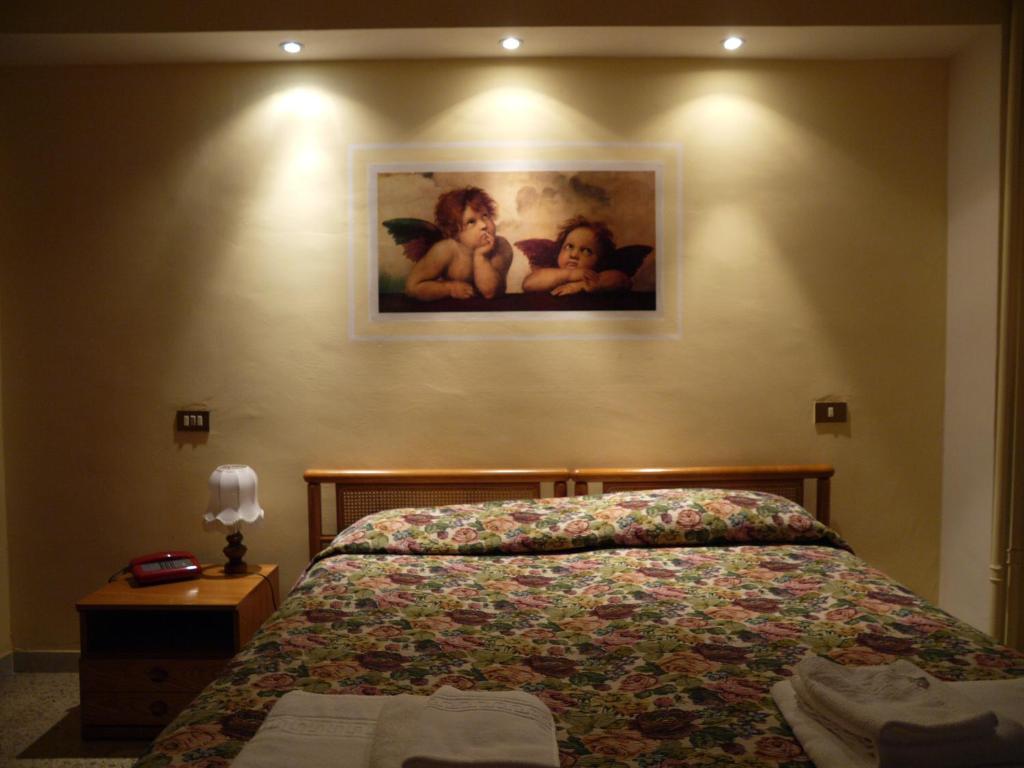 a bedroom with a bed and a painting on the wall at Pensione Lidia in San Salvo