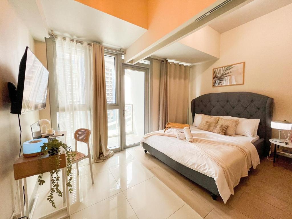 une chambre avec un grand lit et une grande fenêtre dans l'établissement Luxury BGC Condo Near Uptown,Grand Hyatt #upt219k, à Manille