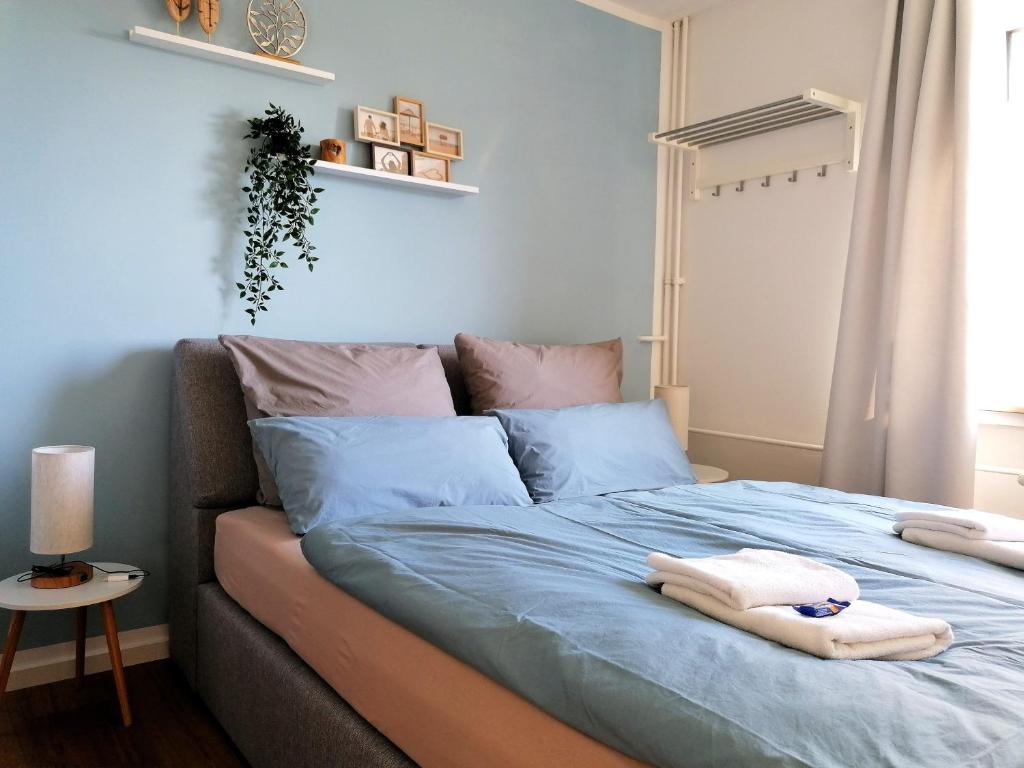 a bedroom with a blue bed with towels on it at M-OASE Blue Design I Citynah I Küche I Netflix in Braunschweig