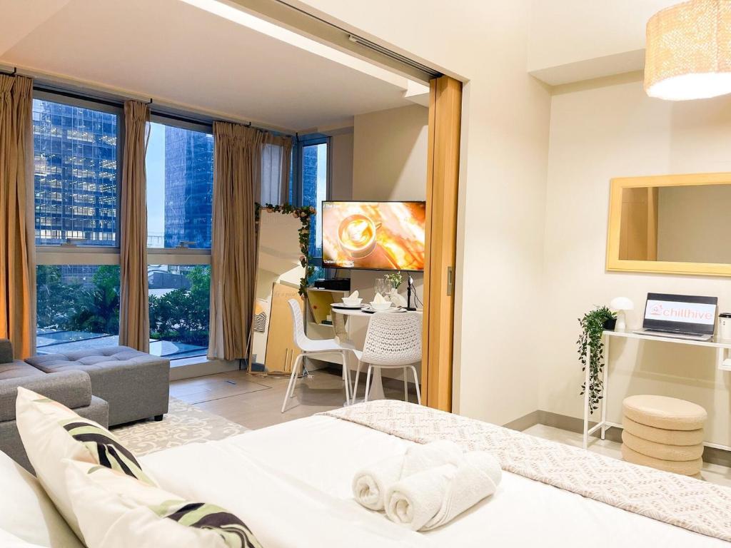 ein Schlafzimmer mit Bett und ein Wohnzimmer in der Unterkunft Prime BGC 1BR Near Mitsukoshi Mall #upt16m in Manila