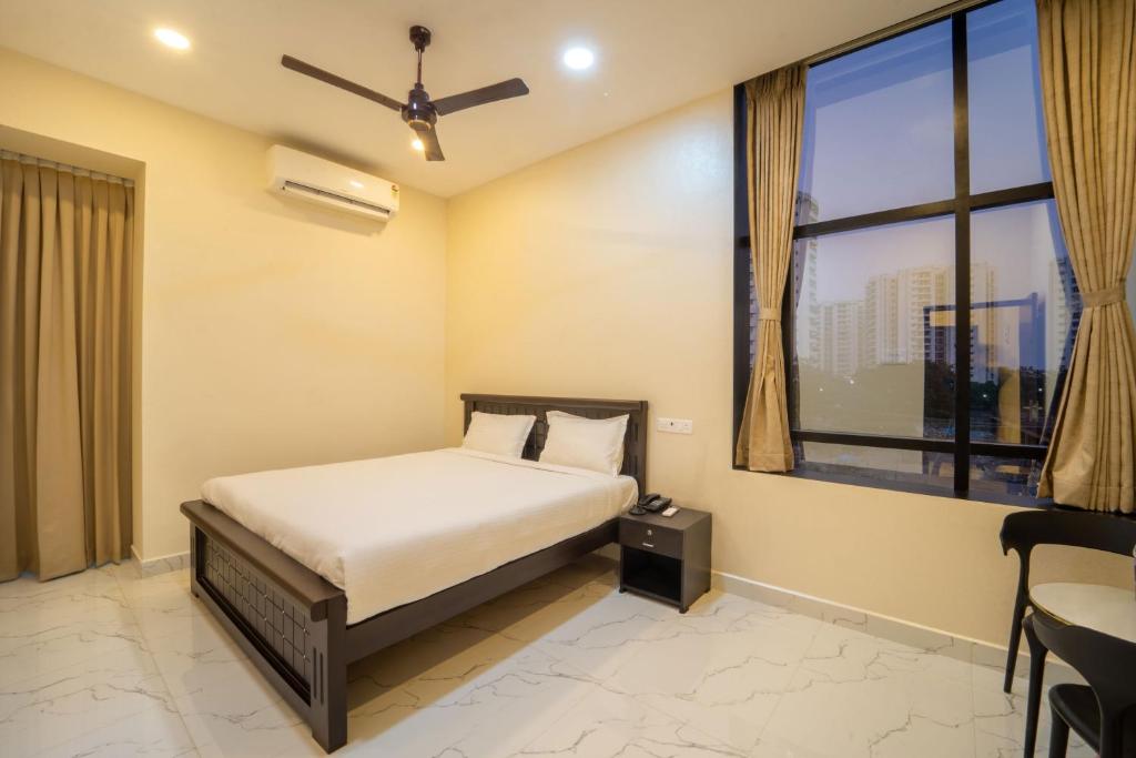 a bedroom with a bed and a large window at VR Paradise - Near SIPCOT Chennai OMR in Kelambākkam