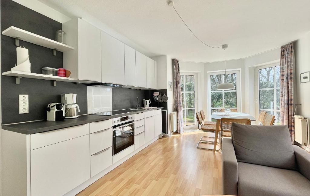 Una cocina con gabinetes blancos y una sala de estar. en 'Edes Huus', en Langeoog