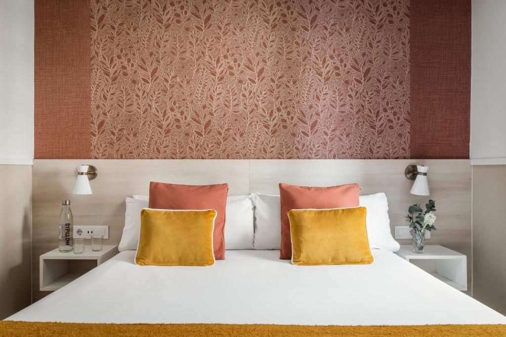 バルセロナにあるBYPILLOW Houseのベッドルーム1室(白いベッド1台、黄色い枕2つ付)