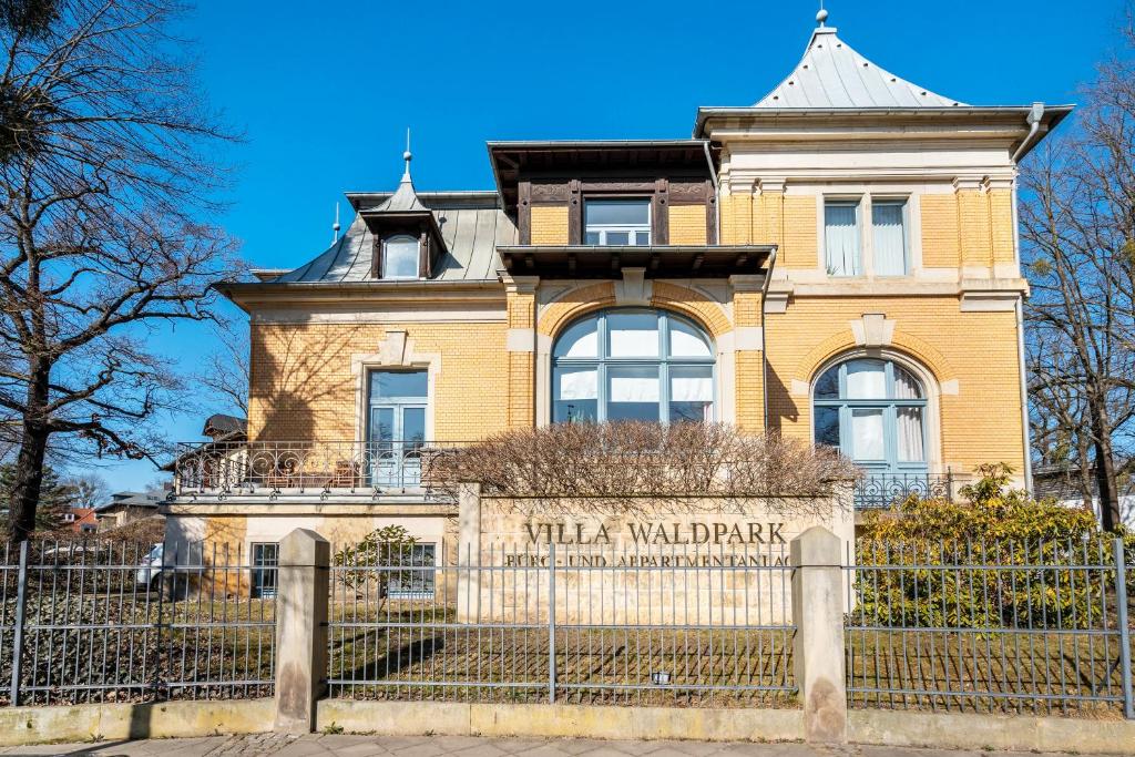 a tall building with a fence in front of it at Villa Waldpark in Dresden
