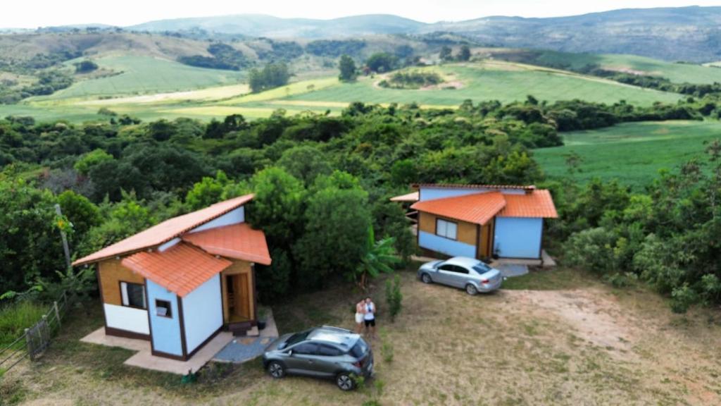 an aerial view of a house and two cars at Sítio Embaú in Carrancas