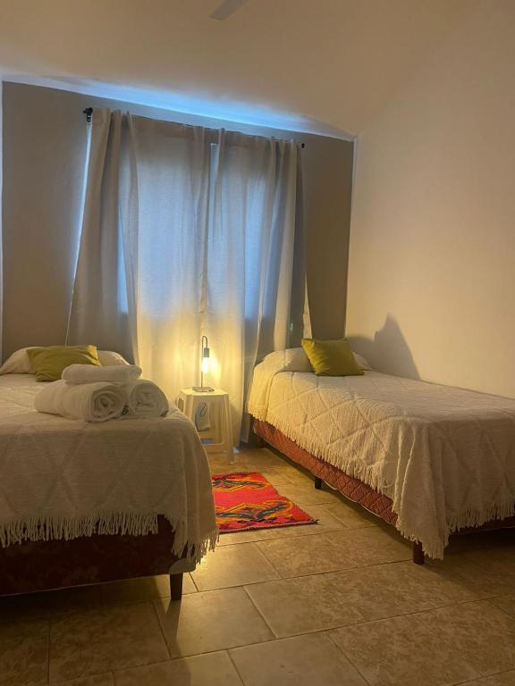 a bedroom with two beds and a blue light at casa San Isidro in Cafayate