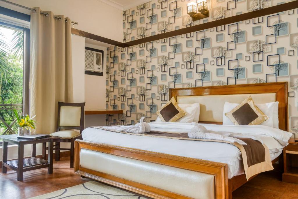 een slaapkamer met een groot bed en een raam bij Maya The Forest Resort in Rāmnagar