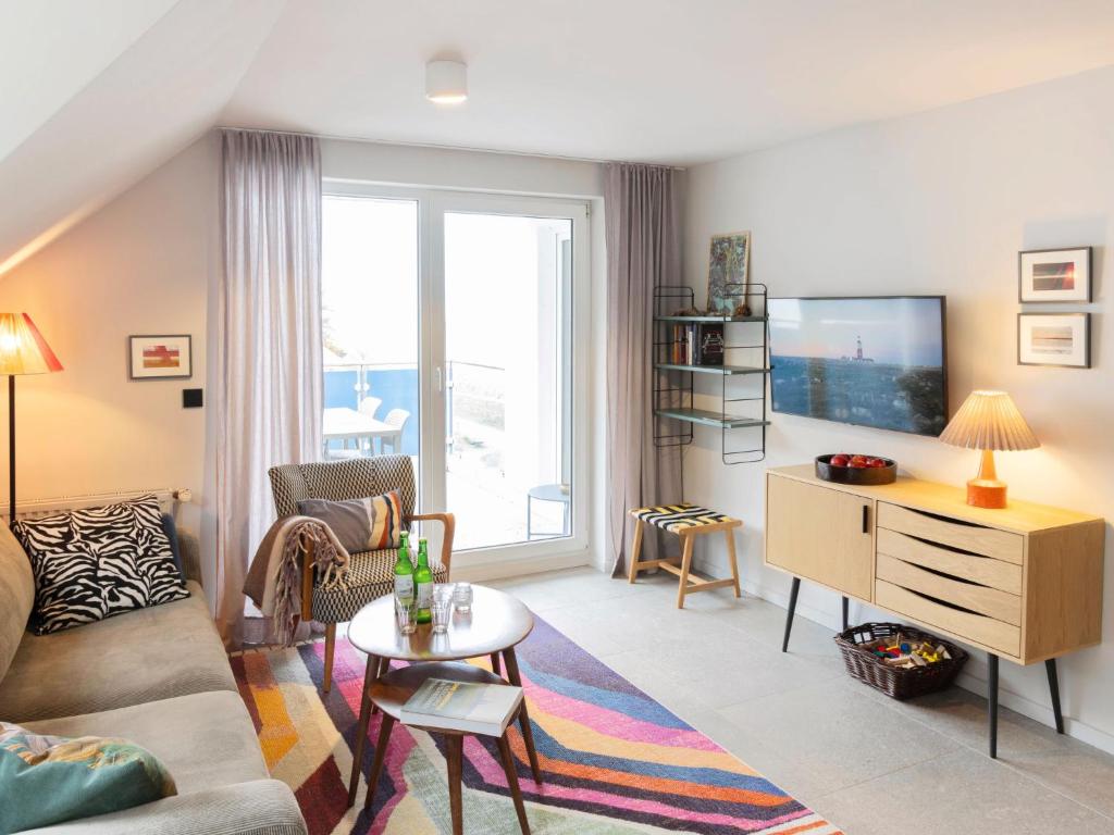 a living room with a couch and a tv at Apartment Blaumuschel - LUB108 by Interhome in Lubmin