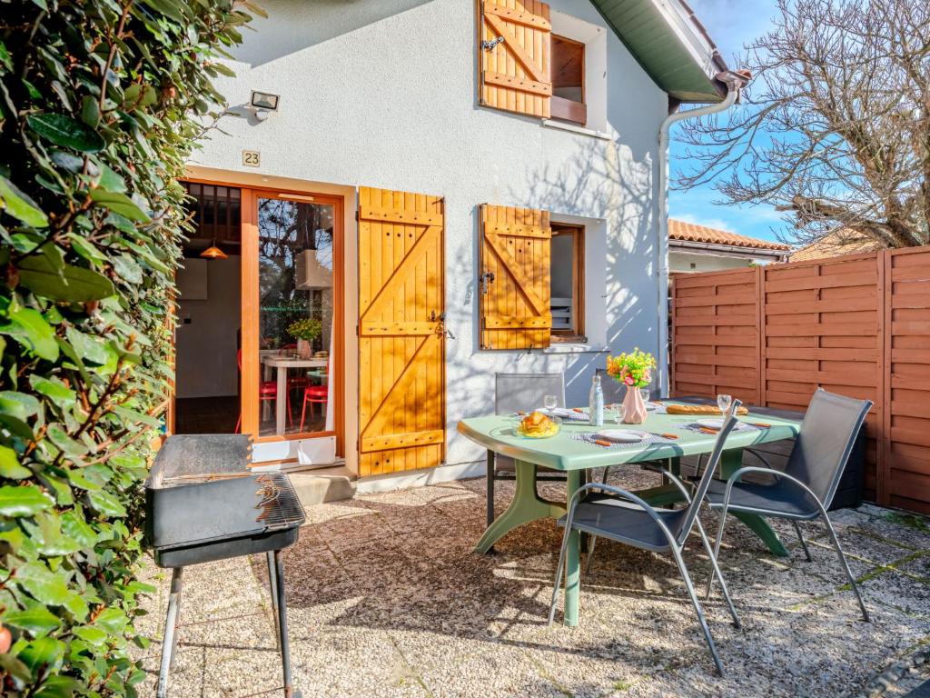 un patio avec une table et des chaises devant une maison dans l'établissement Apartment Les Landaises-5 by Interhome, à Mimizan-Plage
