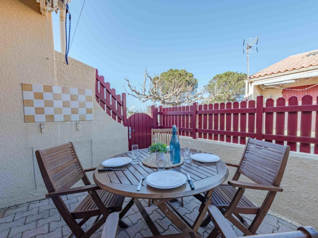 - une table en bois et 2 chaises sur la terrasse dans l'établissement Holiday Home Santa Barbara-11 by Interhome, au Barcarès