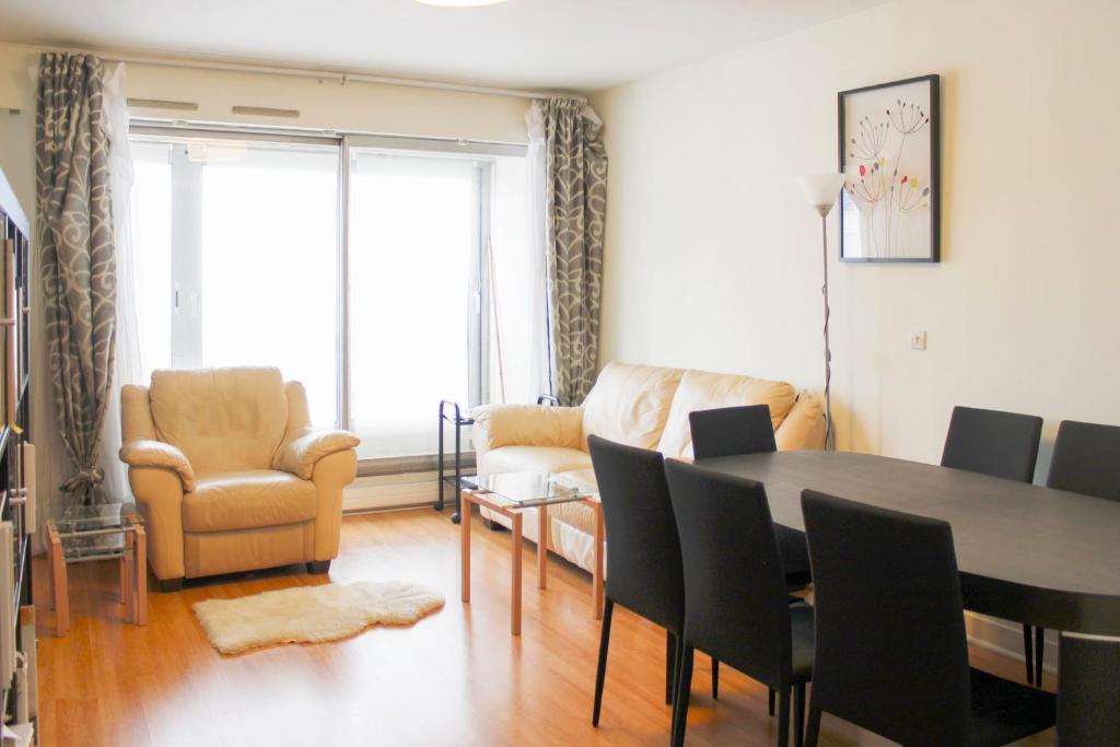 un salon avec une table et des chaises de salle à manger dans l'établissement Spacious 3 rooms with balcony in Paris, à Paris