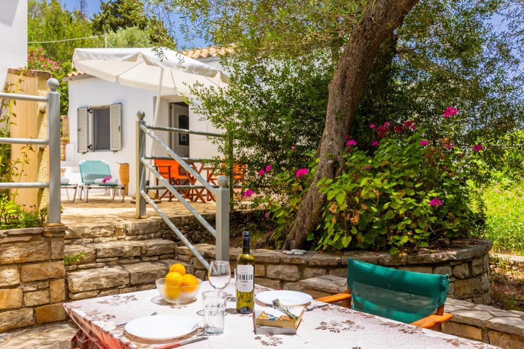 a table with a bottle of wine and some fruit on it at Aimilia Cottage in Longós