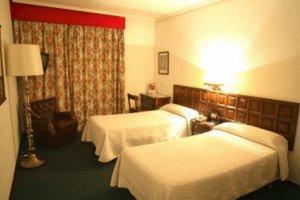 um quarto de hotel com duas camas e uma janela em Monclús em Palencia