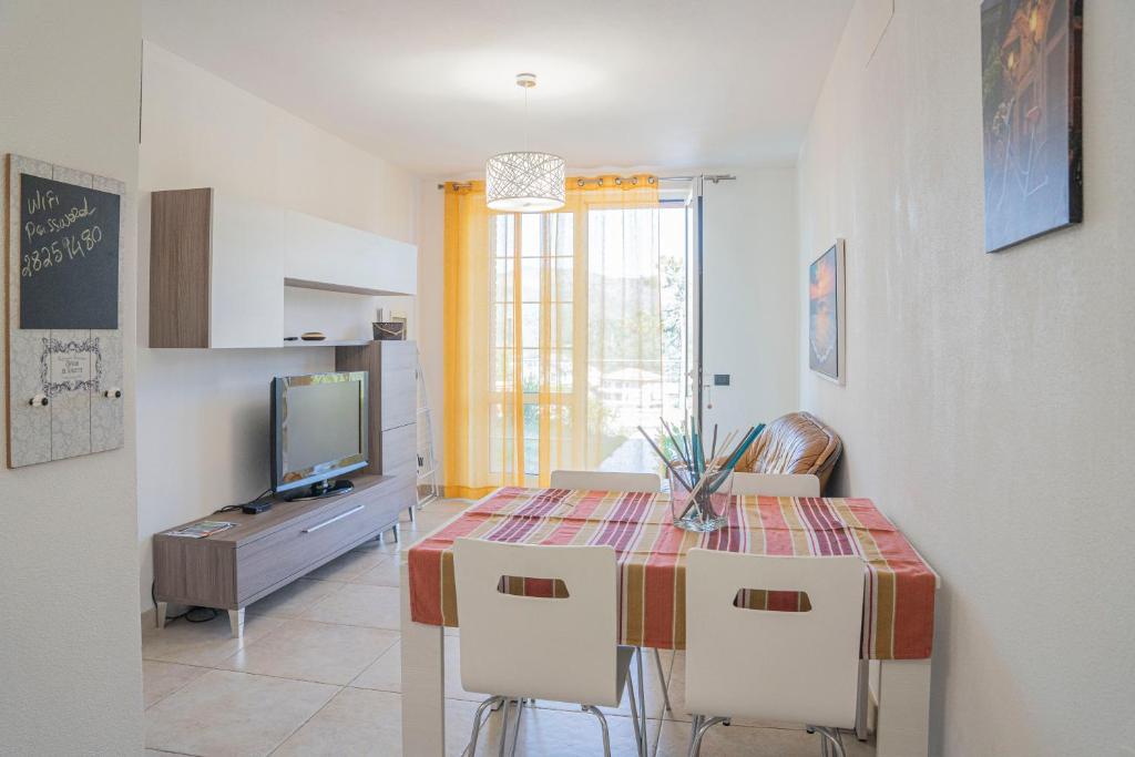 jadalnia ze stołem z krzesłami i telewizorem w obiekcie 065 - VILLA LETIZIA, Elegante 2 PISCINA e Natura, 10 minuti da MARE e SPIAGGIE w mieście Casarza Ligure