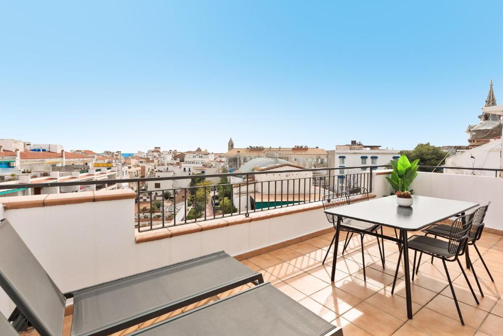 a balcony with a table and chairs and a view at Sitges Group Soul in Sitges