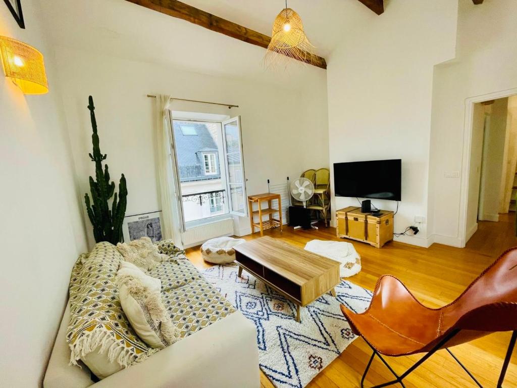 un salon avec un canapé et une télévision dans l'établissement Tour Eiffel Invalides Pierre Leroux, à Paris