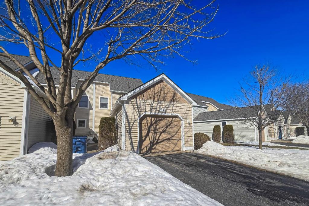 a house with snow on the ground and a tree at Northern Michigan Manistee Magic in Manistee
