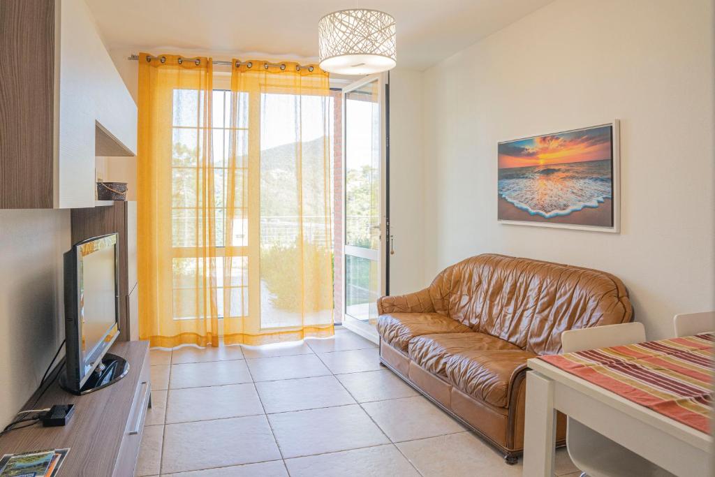salon z kanapą i telewizorem w obiekcie 065 - VILLA LETIZIA, Elegante 2 PISCINA e Natura, 10 minuti da MARE e SPIAGGIE w mieście Casarza Ligure