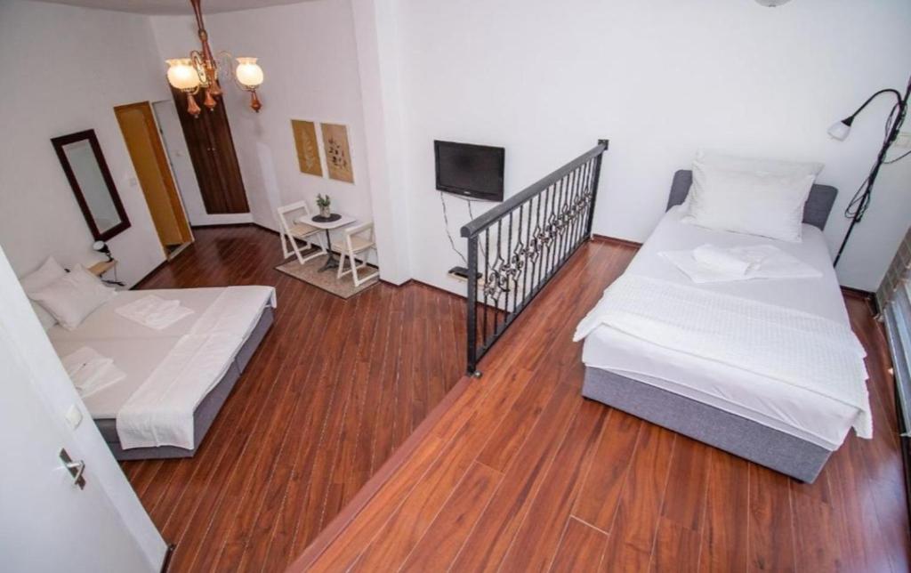 a room with two beds and a television in it at Apartments Isabella in Mostar
