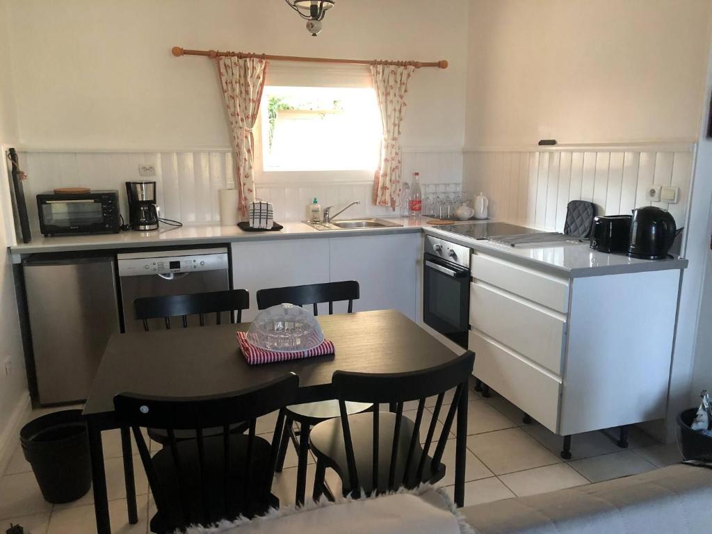 莫龙Bakers Cottage near broceliande forest的带桌子和椅子的厨房