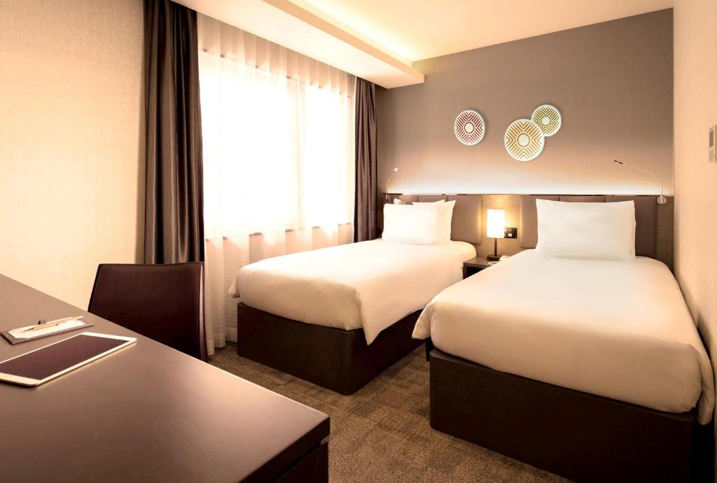 Postel nebo postele na pokoji v ubytování Holiday Inn & Suites Shin Osaka by IHG