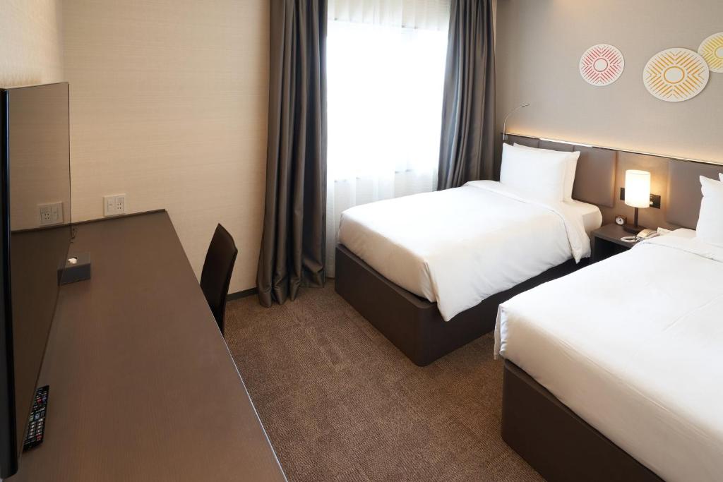 Postel nebo postele na pokoji v ubytování Holiday Inn & Suites Shin Osaka by IHG