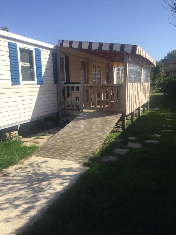 une maison avec une terrasse couverte en bois et une terrasse dans l'établissement k154 Charmettes, aux Mathes
