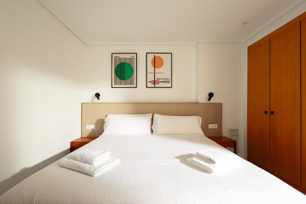 a bedroom with a white bed with two white towels at White Beach Apartment in Valencia