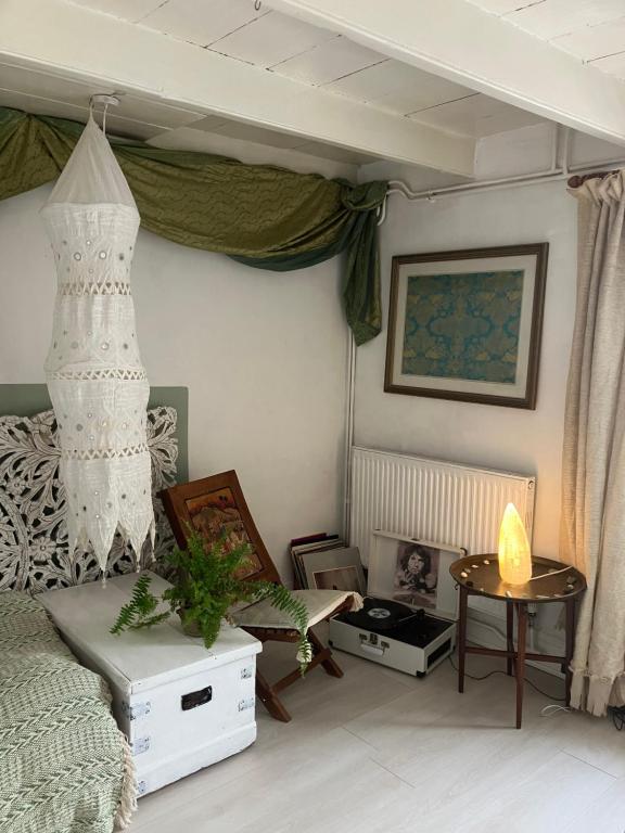 a bedroom with a bed and a dresser and a table at Cornish Cottage in Newquay