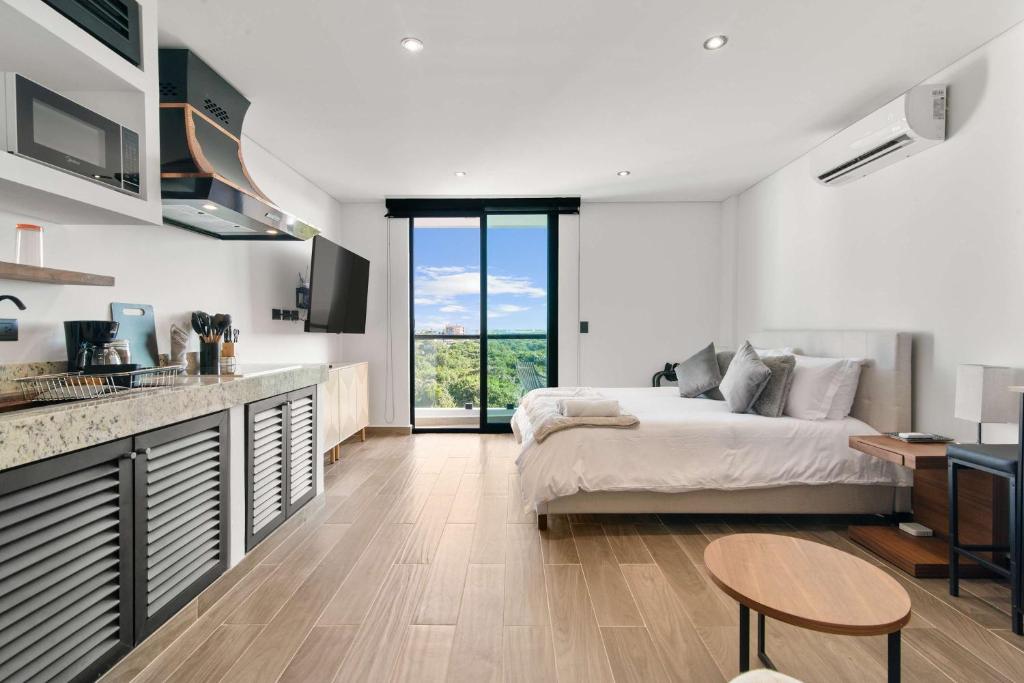 a bedroom with a bed and a kitchen with a counter at Suite Jungle Studio with Views Walk Everywhere in Playa del Carmen