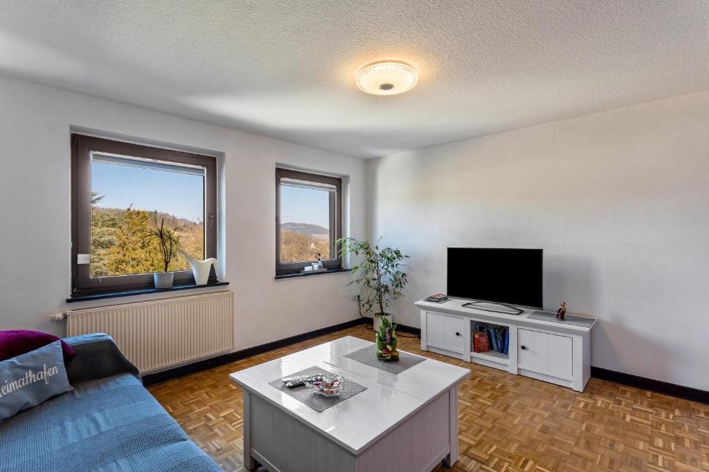 a living room with a blue couch and a tv at Ferienwohnung Ankerplatz, 65qm in Langscheid