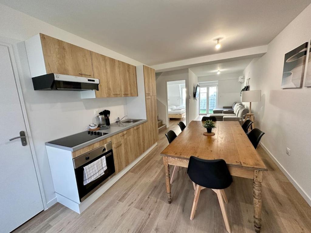 une cuisine avec une table en bois et une salle à manger dans l'établissement Mascate - Appartement avec terrasse privée et climatisation, à Reims