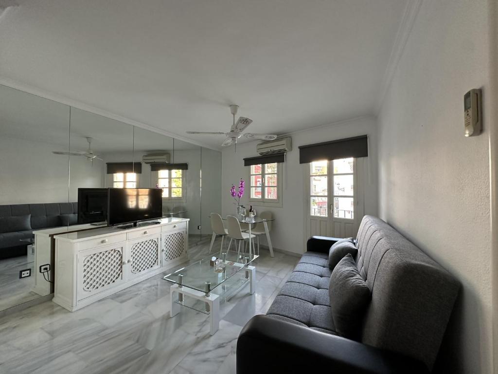 una sala de estar con un sofá y una mesa en Apartamento en pleno centro de Torremolinos, en Torremolinos