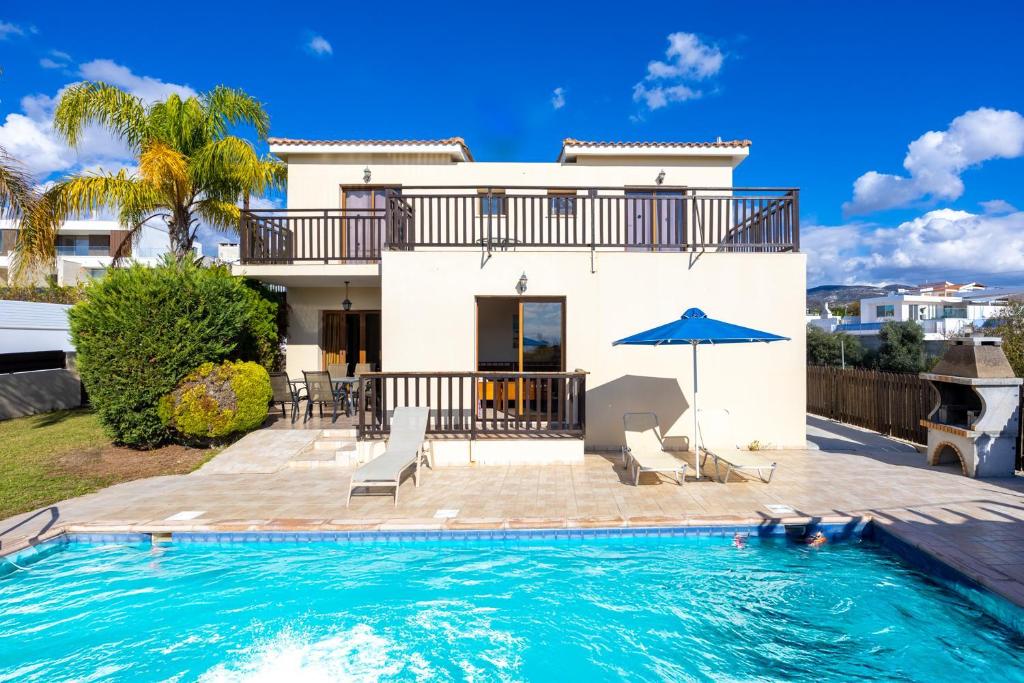 a villa with a swimming pool and a house at Villa Sunlove in Peyia