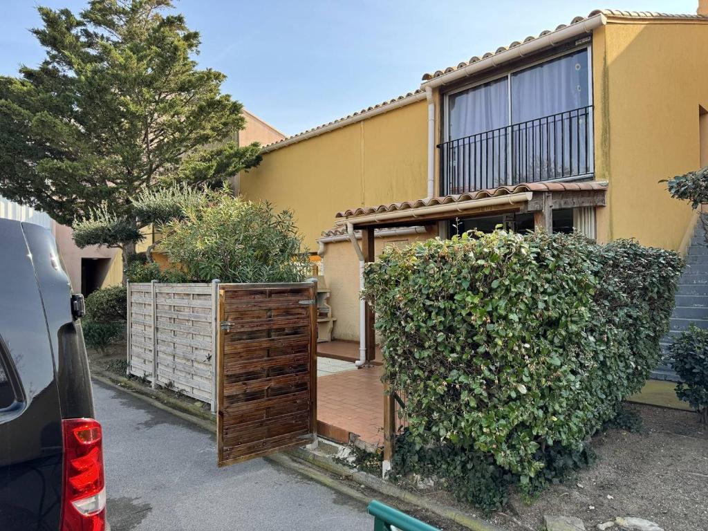 une maison avec une terrasse en bois devant elle dans l'établissement HOLIDAYLAND Résidence Les Balcons de la Méditerranée 2, à Narbonne-Plage
