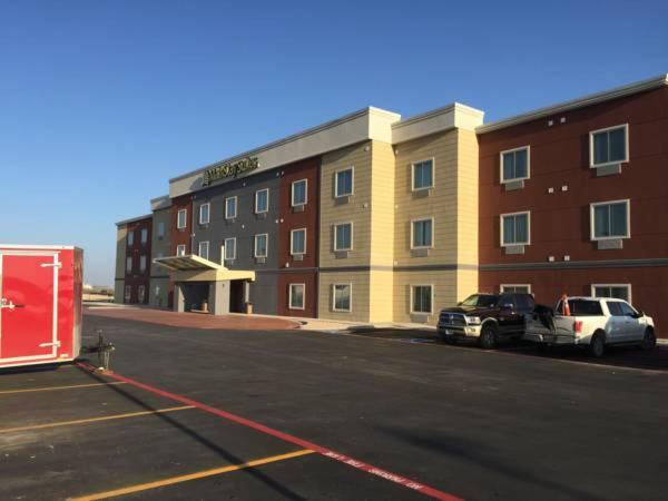 een parkeerplaats met twee auto's geparkeerd voor een gebouw bij MainStay Suites Odessa I-20 in Odessa