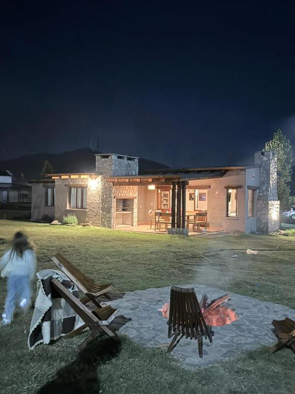 a woman running in front of a house at night at Las Piedras in Tafí del Valle