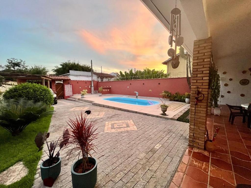 a backyard with a swimming pool and a house at Refúgio ao lado do mar com piscina e muito charme in Ubatuba