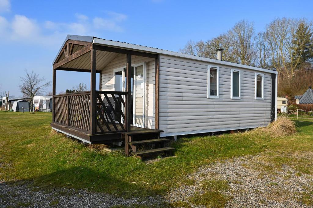 una casetta con un portico su un prato di Ferienpark Süderstapel - Eiderlodge 3 a Süderstapel
